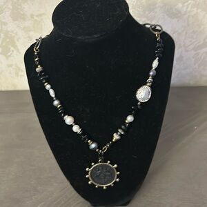 Stunning one of a ind necklace with black emblem.